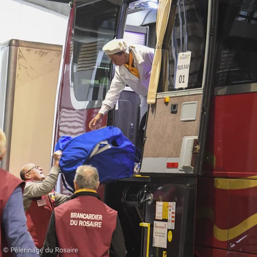 Bénévoles aident voyageurs bus Pèlerinage du Rosaire.
