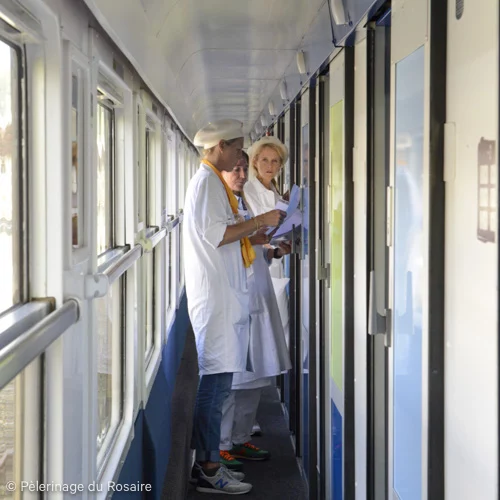 Pèlerins lisant dans le train du Pèlerinage du Rosaire