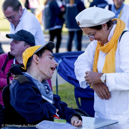 Pèlerinage du Rosaire : homme handicapé parlant à une femme