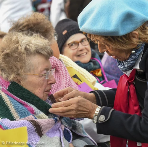 Femme aidant personne âgée au Pèlerinage du Rosaire