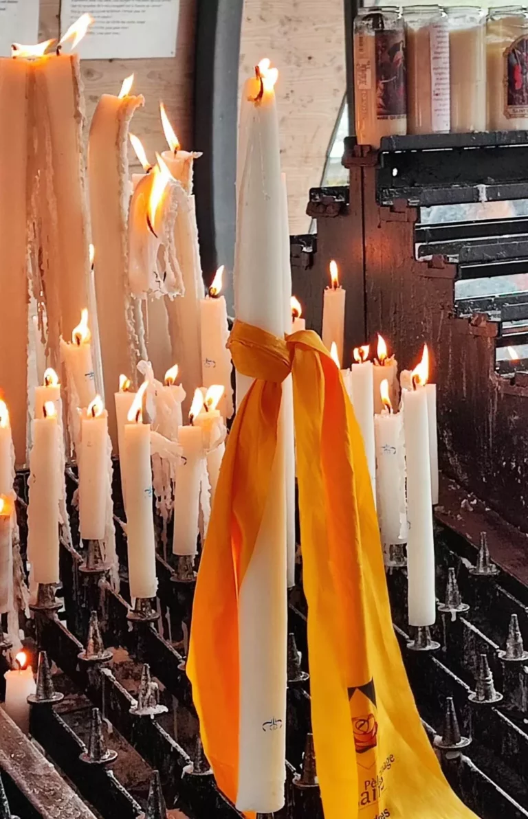 Bougies blanches allumées avec ruban jaune dans une église