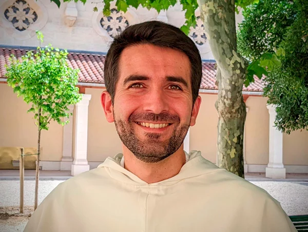 Portrait d'un jeune moine souriant en extérieur