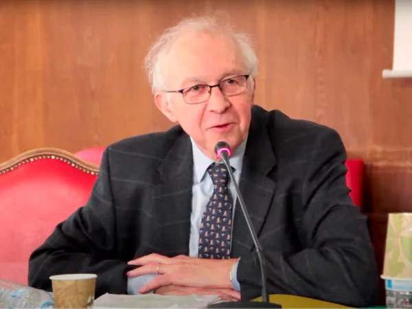 Homme âgé en costume parlant au micro lors conférence