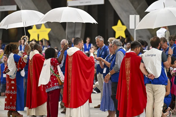 Foule de personnes diverses lors d'une cérémonie religieuse internationale.