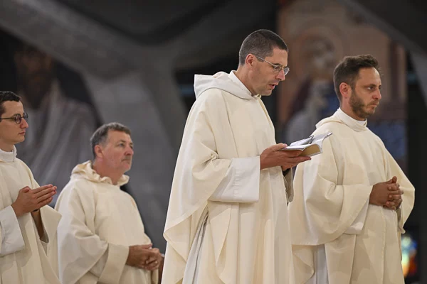 Prêtres catholiques en cérémonie religieuse, lecture d'un livre