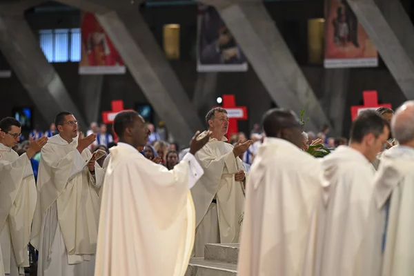Prêtres en robes blanches lors d'une cérémonie religieuse.