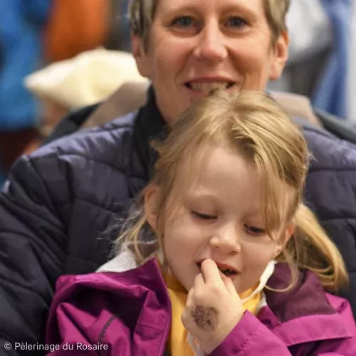Femme souriante avec enfant regardant sa main