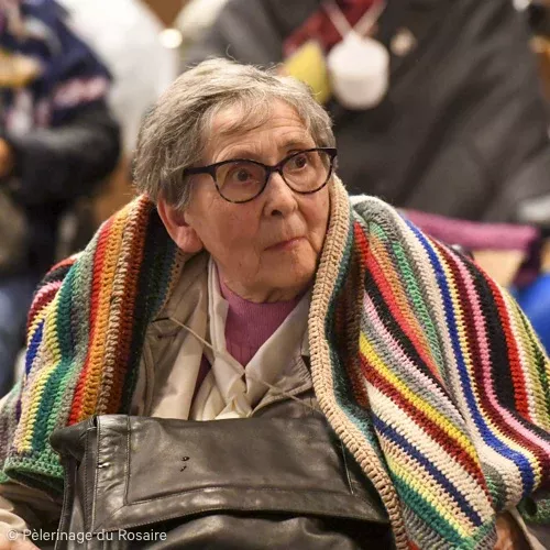 Femme âgée souriante avec un châle coloré au pèlerinage
