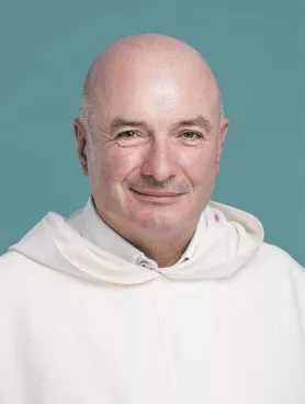 Portrait d'un homme chauve souriant avec une capuche blanche.