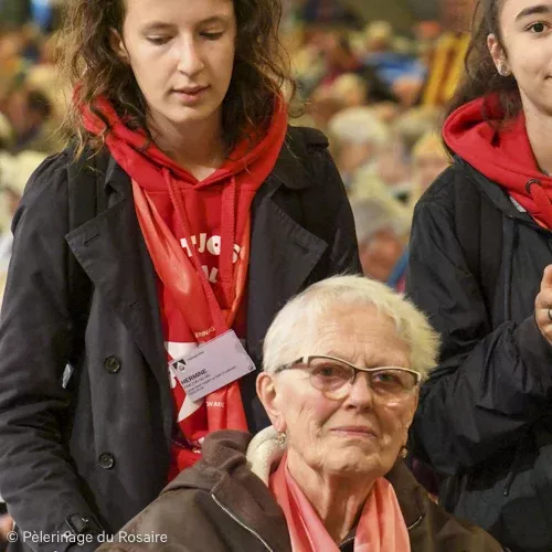 Pèlerinage du Rosaire: Bénévoles aident personne âgée en fauteuil roulant