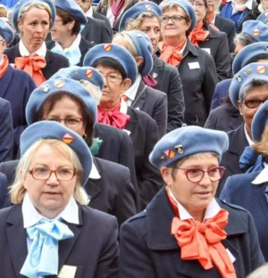 Groupe de femmes en bérets bleus et foulards colorés.