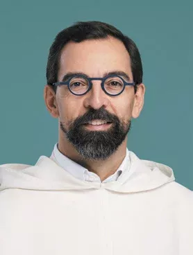 Portrait d'un père dominicain souriant avec des lunettes rondes